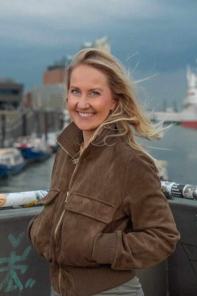 Michelle Aßenmacher am Hamburger Hafen, im Hintergrund die Elbphilharmonie